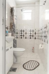 a white bathroom with a toilet and a shower at Nora Apartments in Jagodina +43 photos