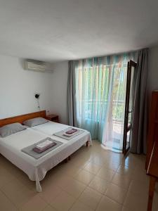 a bedroom with a bed and a large window at Guest House Karavida in Sinemorets