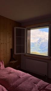 a bedroom with a window with a view of a mountain at Stöcki-Grindelwaldblick in Kleine Scheidegg +3 photos
