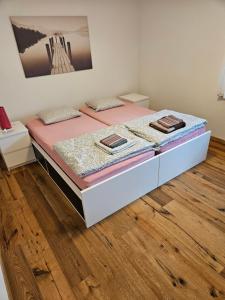 a bedroom with a bed with pink sheets and wooden floors at Ferienwohnung Sesvenna Davos in Davos