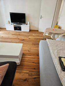 a living room with a tv and a wooden floor at Ferienwohnung Sesvenna Davos in Davos