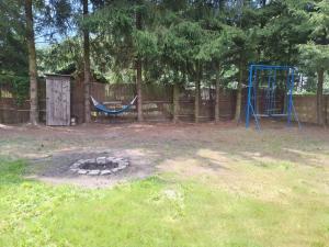 a playground with a hammock and a swing set at Mazurska Chatka Pilchy in Pilchy