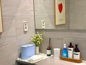 a bathroom counter with cosmetics and flowers on it at Mood-Ocean 영종도 오션파크나인호텔 in Chagyak-to