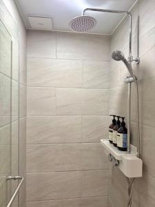 a bathroom with a shower with two bottles of wine at Mood-Ocean 영종도 오션파크나인호텔 in Chagyak-to
