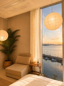 a bedroom with a couch and a window with a view at Mood-Ocean 영종도 오션파크나인호텔 in Chagyak-to