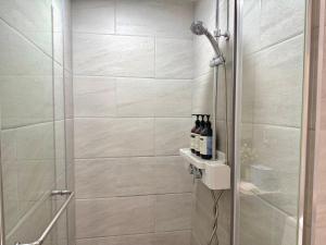 a shower with a glass door with bottles on a shelf at Mood-Ocean 영종도 오션파크나인호텔 in Chagyak-to +6 photos