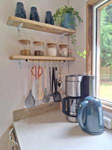 a kitchen counter with a coffee maker and utensils at Mazurska Chatka Pilchy in Pilchy