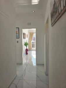 a hallway with white walls and a plant in a vase at Flourish Haven Escape in Germiston