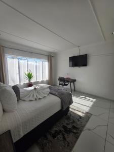 a bedroom with a bed and a window and a table at Flourish Haven Escape in Germiston