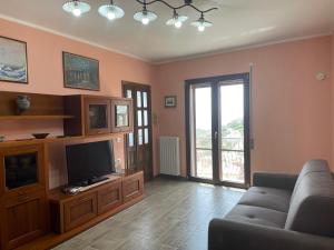 a living room with a couch and a flat screen tv at La Quiete dei Tacchi Ulassai in Ulassai +20 photos