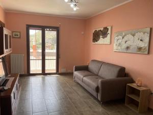 a living room with a couch and a television at La Quiete dei Tacchi Ulassai in Ulassai