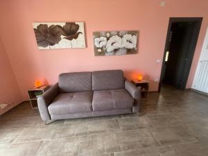 a living room with a couch and two pictures on the wall at La Quiete dei Tacchi Ulassai in Ulassai