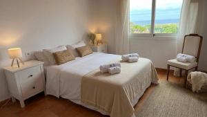 a bedroom with a bed with two towels on it at Villa Miramar Vistas espectaculares in Es Mercadal