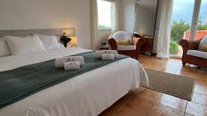 a bedroom with a large bed with two towels on it at Villa Miramar Vistas espectaculares in Es Mercadal