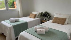 two beds with towels on them in a room at Villa Miramar Vistas espectaculares in Es Mercadal