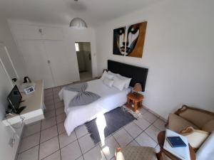 a bedroom with a white bed and a couch at Mahem Guest House in Memel