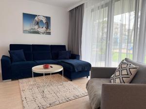 a living room with a blue couch and a table at Apartamenty Marco Polo in Dziwnówek +50 photos