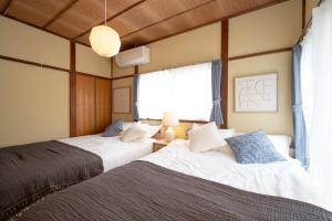 two beds sitting next to each other in a bedroom at 横須賀-1軒家2棟 in Yokosuka