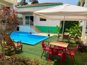 a patio with a table and chairs and an umbrella at Hotel PZero in São Tomé