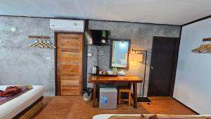 a room with a table and a mirror and a bed at Khao Sok Cabana Resort in Khao Sok National Park