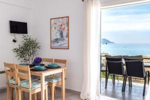 a dining room with a table and a view of the ocean at Corfu Dream Holidays Villas Standarts in Glyfada