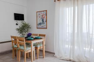 a dining room with a table and chairs and a window at Corfu Dream Holidays Villas Standarts in Glyfada
