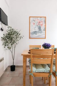 a dining room table with a wooden chair and a plant at Corfu Dream Holidays Villas Standarts in Glyfada +32 photos