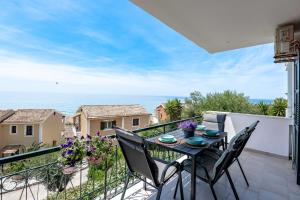 a balcony with a table and chairs and the ocean at Corfu Dream Holidays Villas Standarts in Glyfada