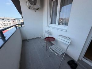 a balcony with two chairs and a table and a window at Apartman S52 City Centre in Doboj
