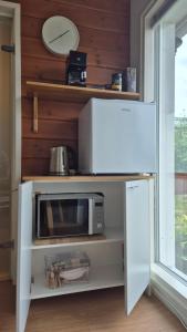 a microwave on a shelf in a kitchen at Saunatupa Kajaani in Kajaani