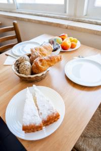 a table with plates of bread and fruit on it at Innpiero in Taormina