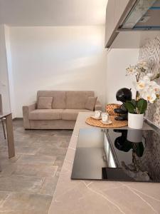 a living room with a couch and a table at Orchidea Apartments in Sorso