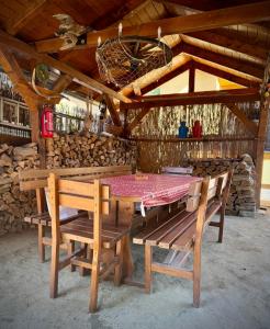 a picnic table and benches in a cabin at Kovács Vendégház in Harkány