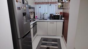 a small kitchen with white cabinets and a refrigerator at Eden House Șelari in Şelari +27 photos