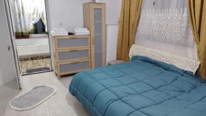 a bedroom with a blue bed and a mirror at Eden House Șelari in Şelari