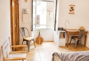 a kitchen with a table and chairs in a room at Charmant appartement climatisé en plein coeur du village et proche des plages avec wifi in Cervione