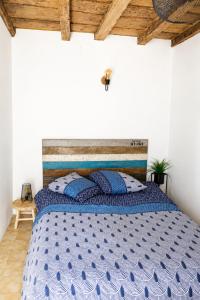 a bedroom with a bed with a blue comforter at Charmant appartement climatisé en plein coeur du village et proche des plages avec wifi in Cervione