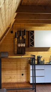 a kitchen with white cabinets and a wooden ceiling at Lunara Chalet in Kazbegi