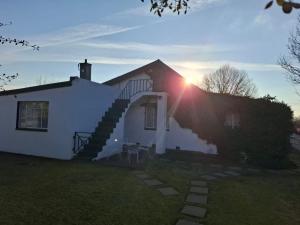 a white house with a staircase on the side of it at Mahem Guest House in Memel