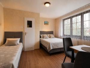 a bedroom with two beds and a desk and a table at Magnat Dźwirzyno in Dźwirzyno