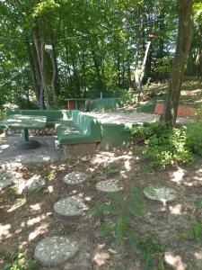 a green bench sitting in the middle of a park at Cabin Hill Station Queen in Sarajevo