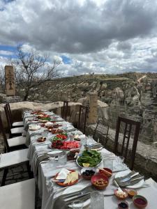 a long table with plates of food on it at Hush Cappadocia Hotel in Ürgüp