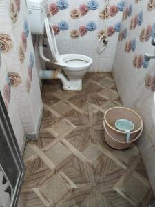 a bathroom with a toilet and a wooden floor at Hotel Lotus in kolkata