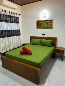 a bedroom with a bed with two red pillows on it at Feather Villa in Talpe