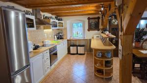 a large kitchen with a stainless steel refrigerator at Zacisze 13 in Leśna