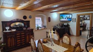 a dining room with a table and a television in a room at Zacisze 13 in Leśna