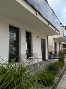 a patio with chairs and a table on a building at Apartamenty Marco Polo in Dziwnówek