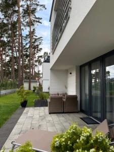 a patio with a couch on the side of a house at Apartamenty Marco Polo in Dziwnówek