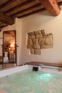 a hot tub in a room with a stone wall at Il Castelluccio Country Resort Restaurant & SPA in Barberino di Mugello