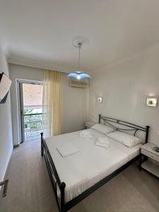 a bedroom with a bed and a large window at Tsakalos Apartments in Edipsos